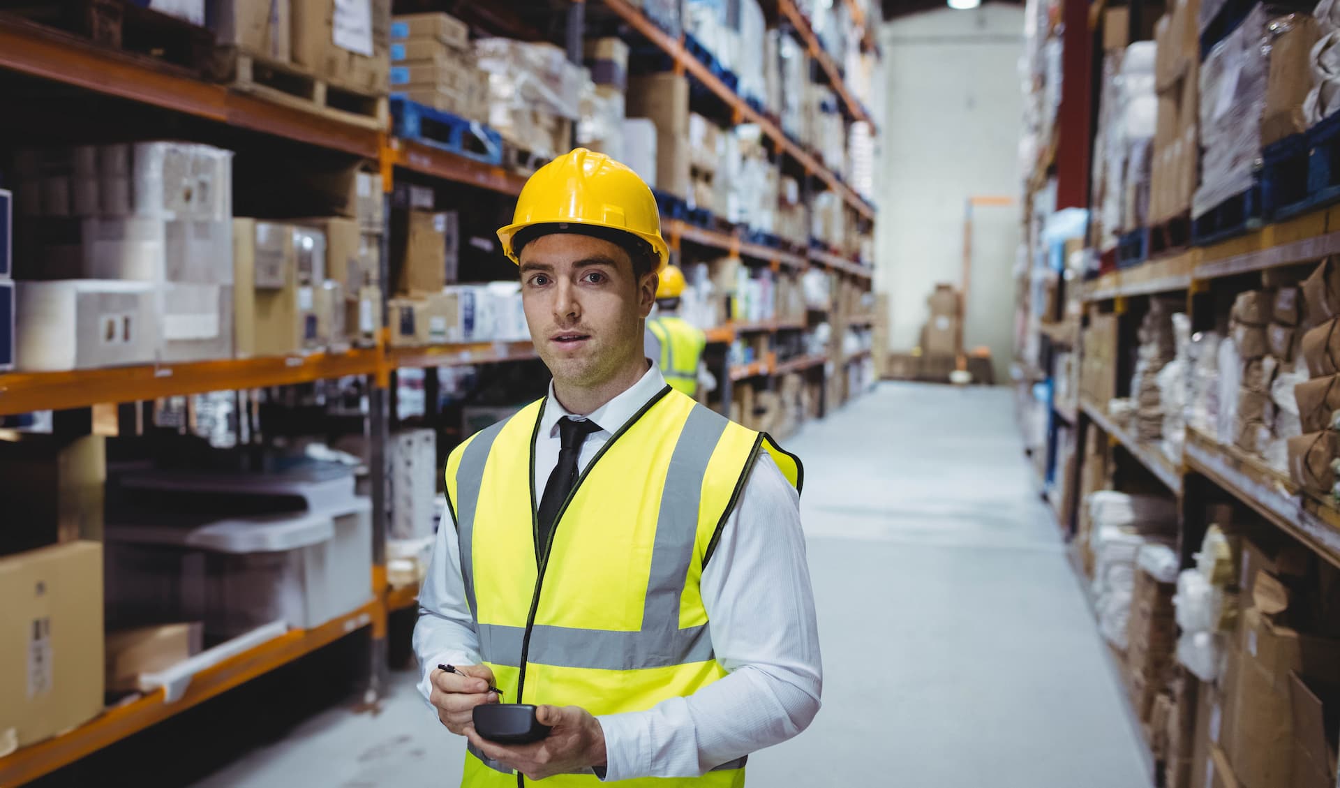 Warehouse team member wearing a hardhat and reflective vest